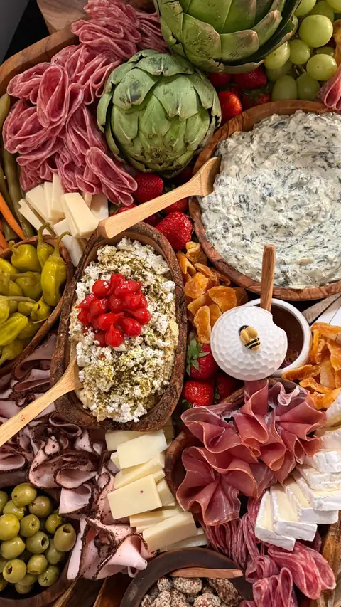 Overhead view of a Taste of Tev grazing table with artichokes, cured meats, cheeses and dips